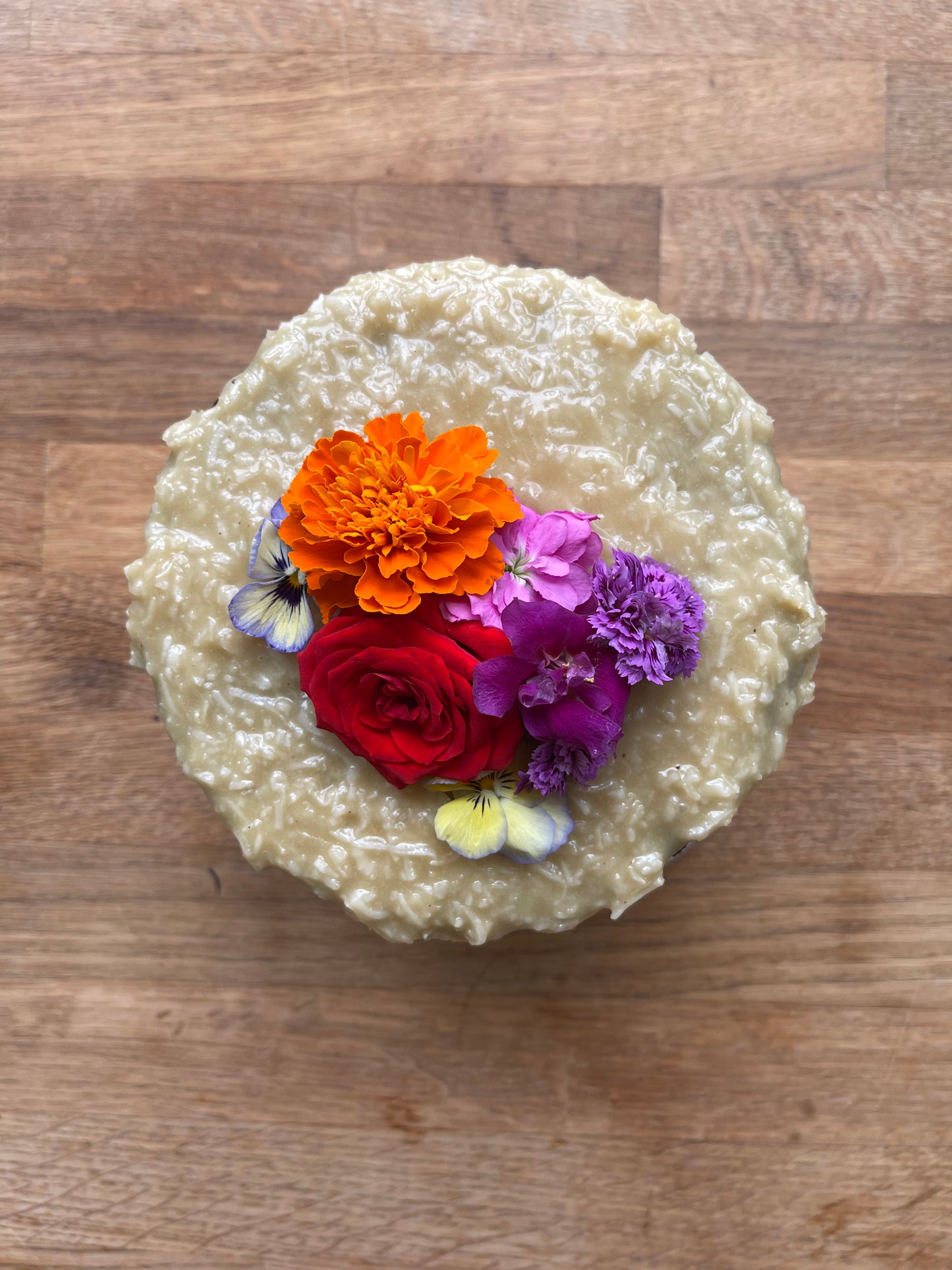 A look from the top of the cake masked with coconut brigadeiro and beautiful edible flowers 