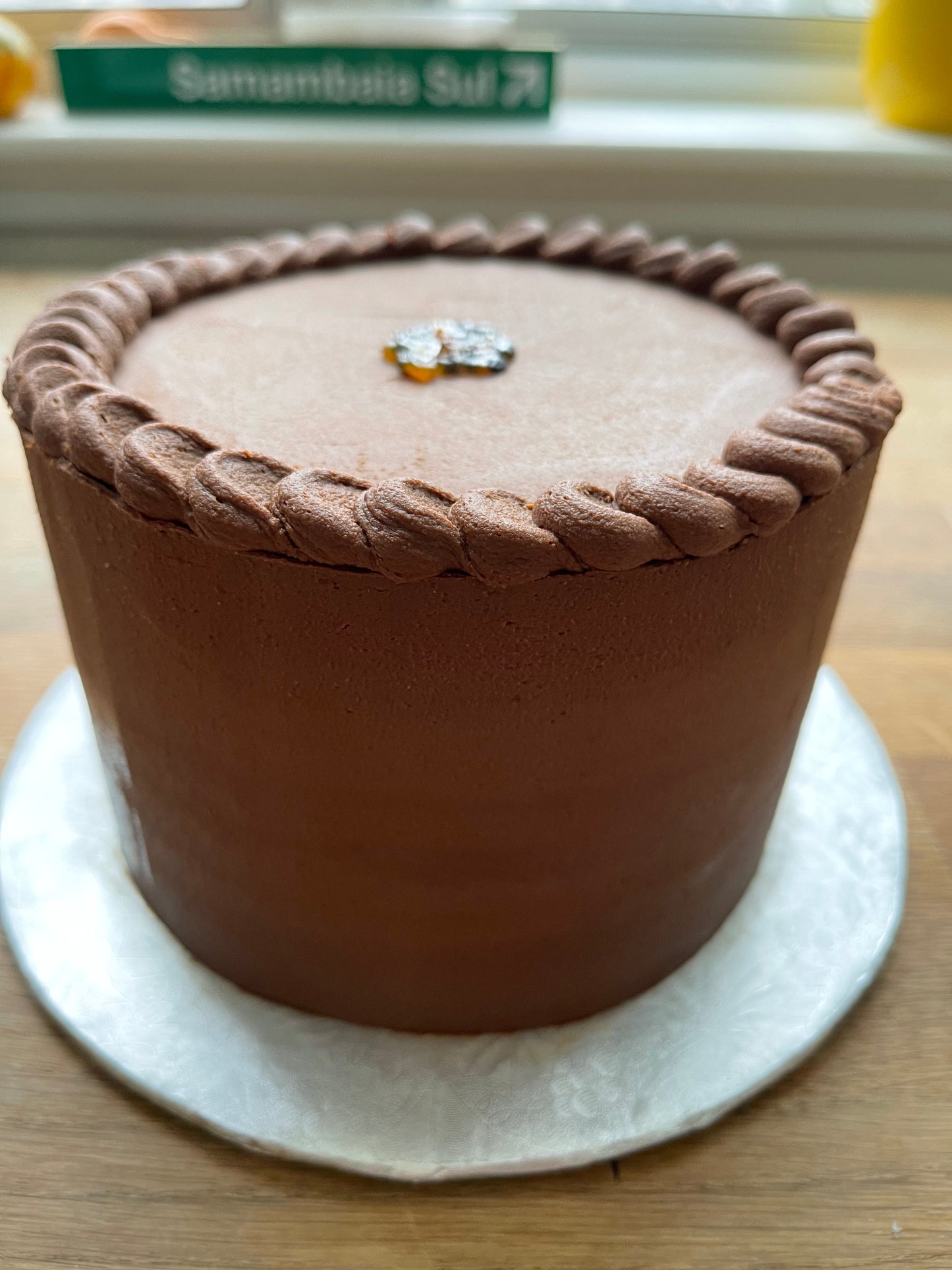 Chocolate cake filled with passion fruit brigadeiro, masked with ganache display in silver board 